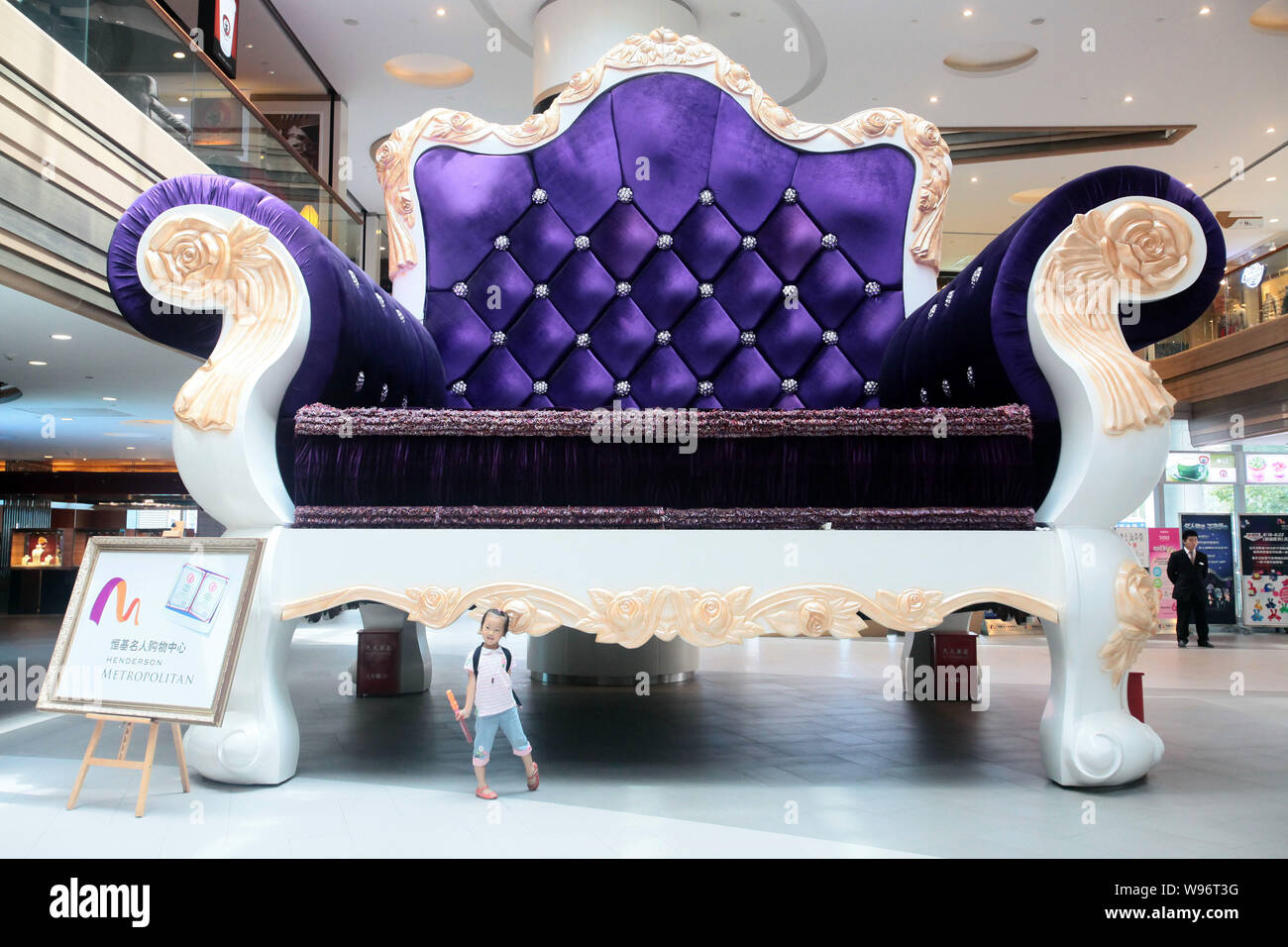 A kid poses in front of the worlds biggest sofa at a mall in Shanghai