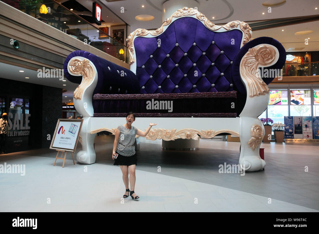 A shopper poses in front of the worlds biggest sofa at a mall in