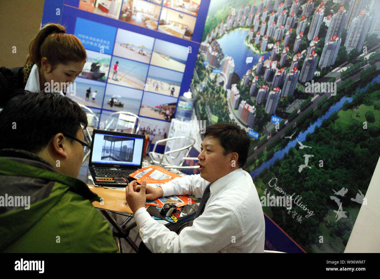 A Chinese salesman introduces a residential apartment project to a homebuyer during the Shanghai Spring Real Estate Trade Fair 2012 in Shanghai, China Stock Photo