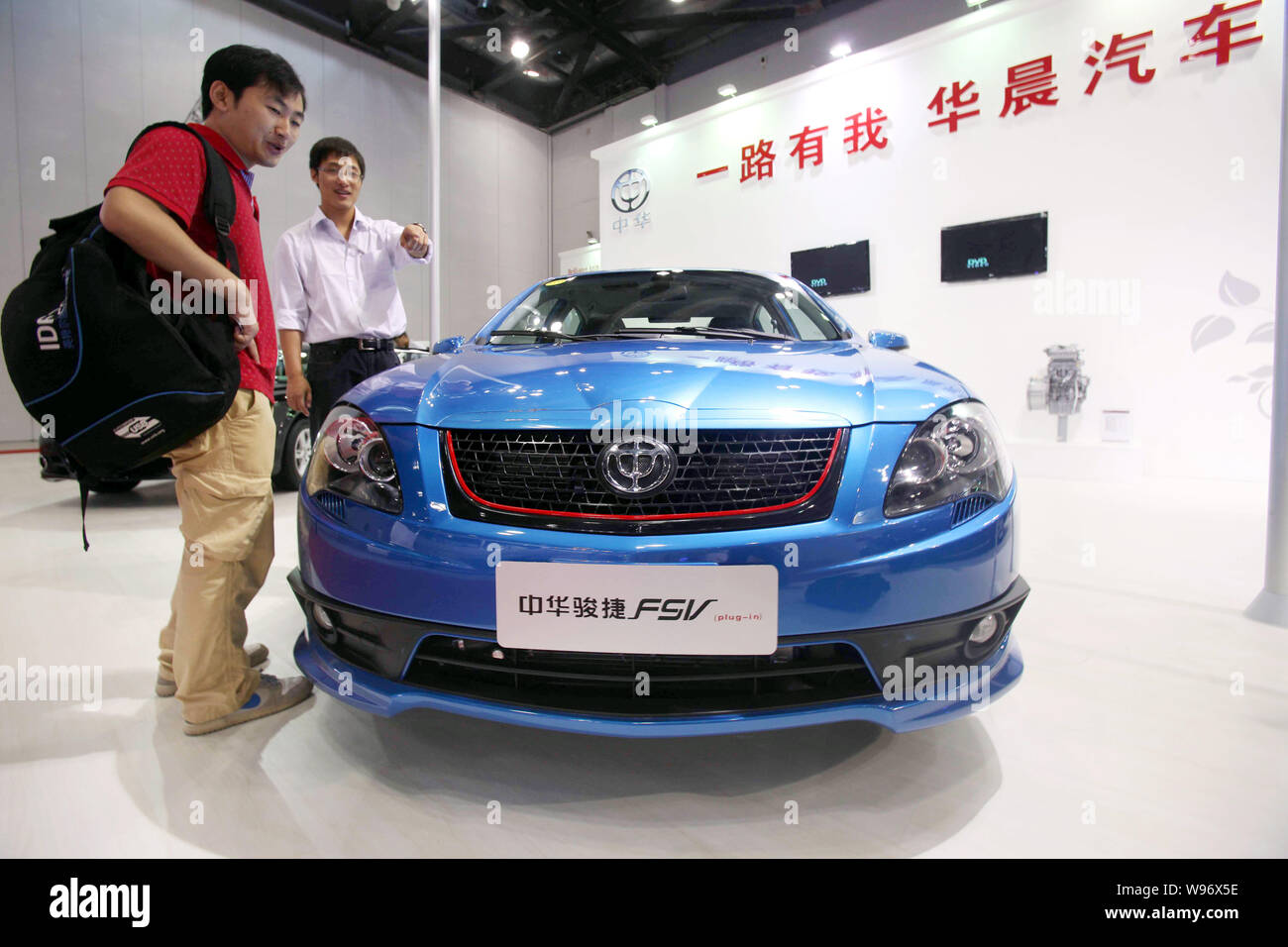 --FILE--An employee of Brilliance Auto introduces a Brilliance FSV to a visitor during an exhibition in Beijing, China, 6 September 2011.   Brilliance Stock Photo