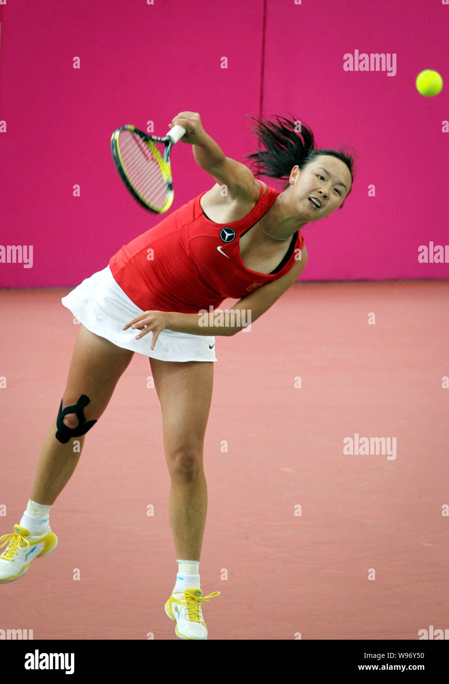 Peng Shuai of China serves against Yaroslava Shvedova of Kazakstan in their Group I match during the 2012 Fed Cup Asia Zone Tennis Tournament in Shenz Stock Photo