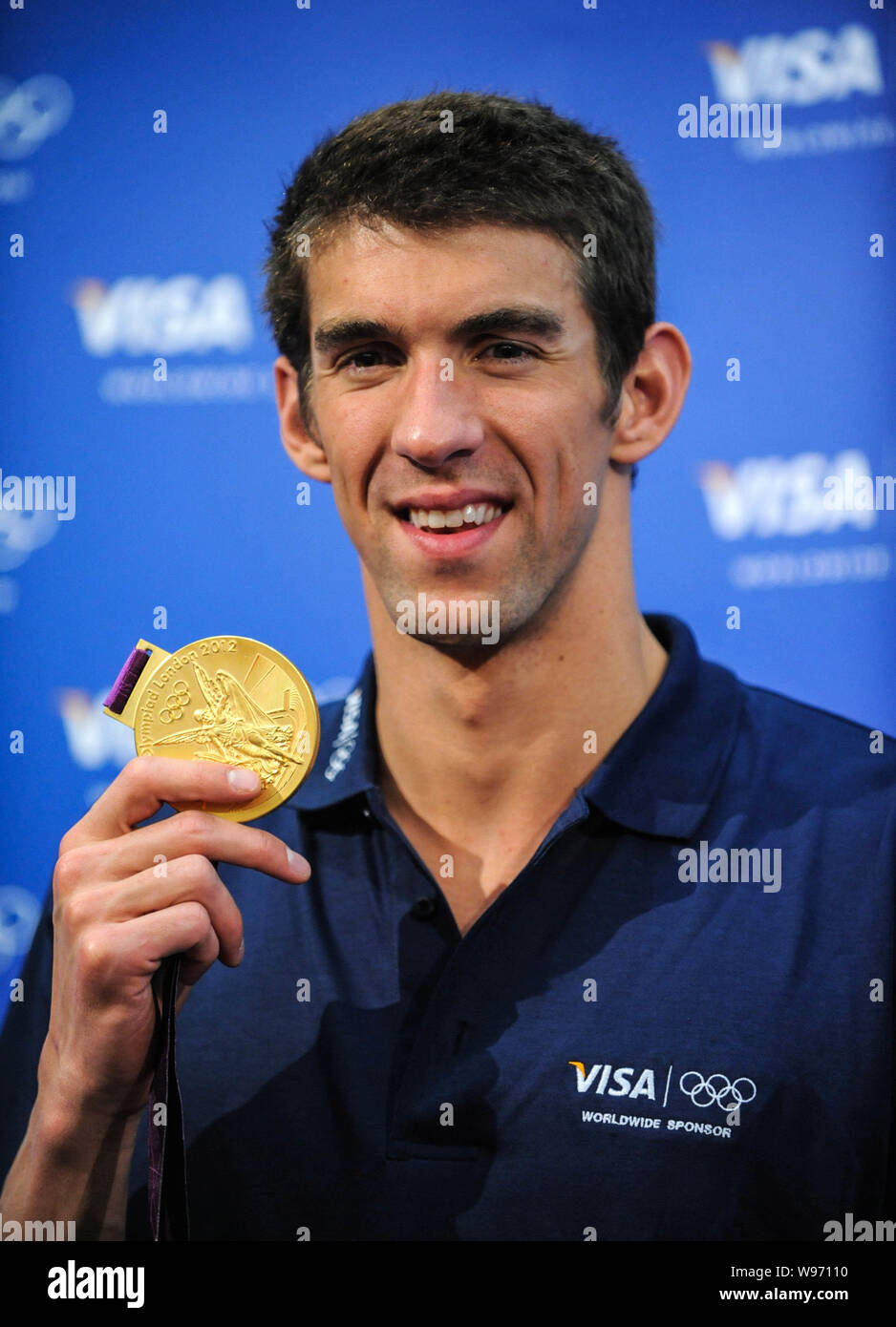 US swimmer Michael Phelps shows one of his gold medals at a press