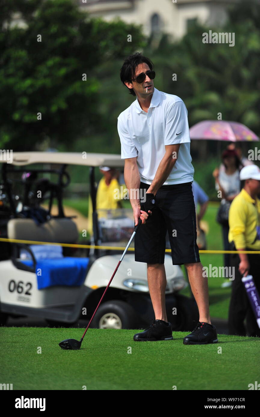 US actor and film producer Adrien Brody smokes as he prepares to tee off during the 2012 Mission Hills World Celebrity Pro-Am golf tournament in Haiko Stock Photo