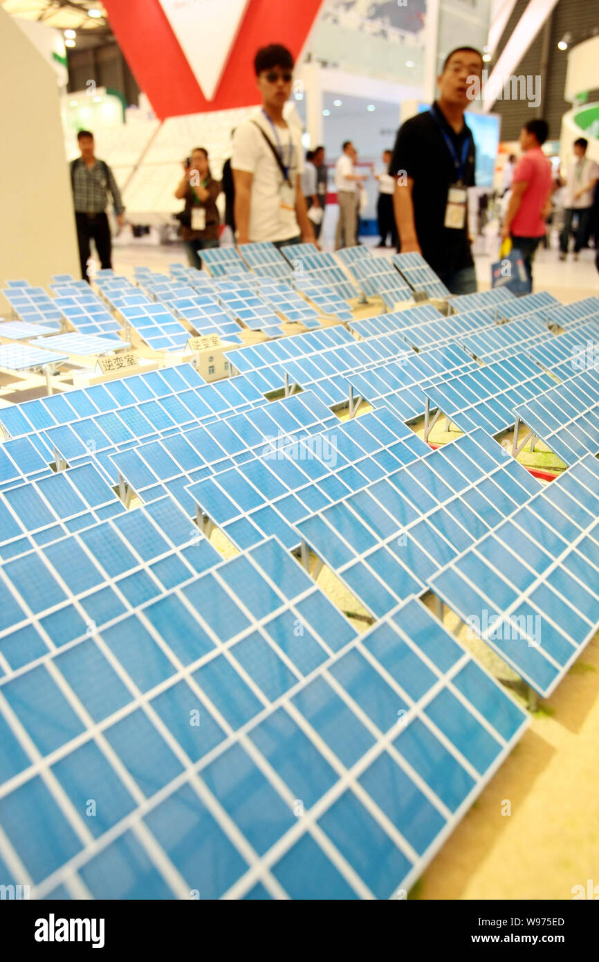 Visitors walk past models of solar panels during the SNEC 6th (2012) International Photovoltaic Power Generation Conference & Exhibition, known as SNE Stock Photo