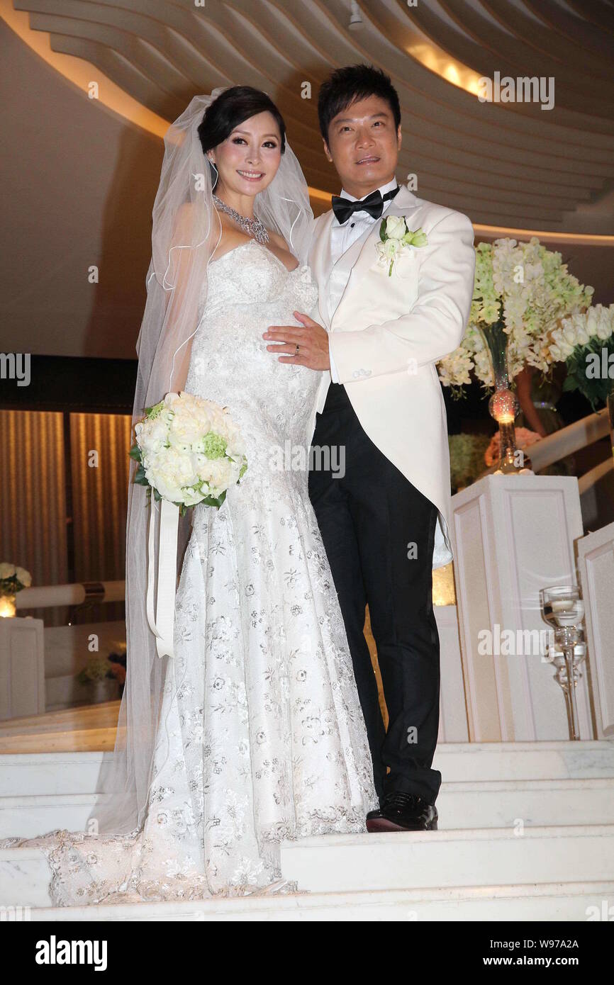 Hong Kong actor Chin Ka Lok, right, strokes the belly of his pregnant actress wife Angela Tong during their wedding ceremony in Hong Kong, China, Thur Stock Photo