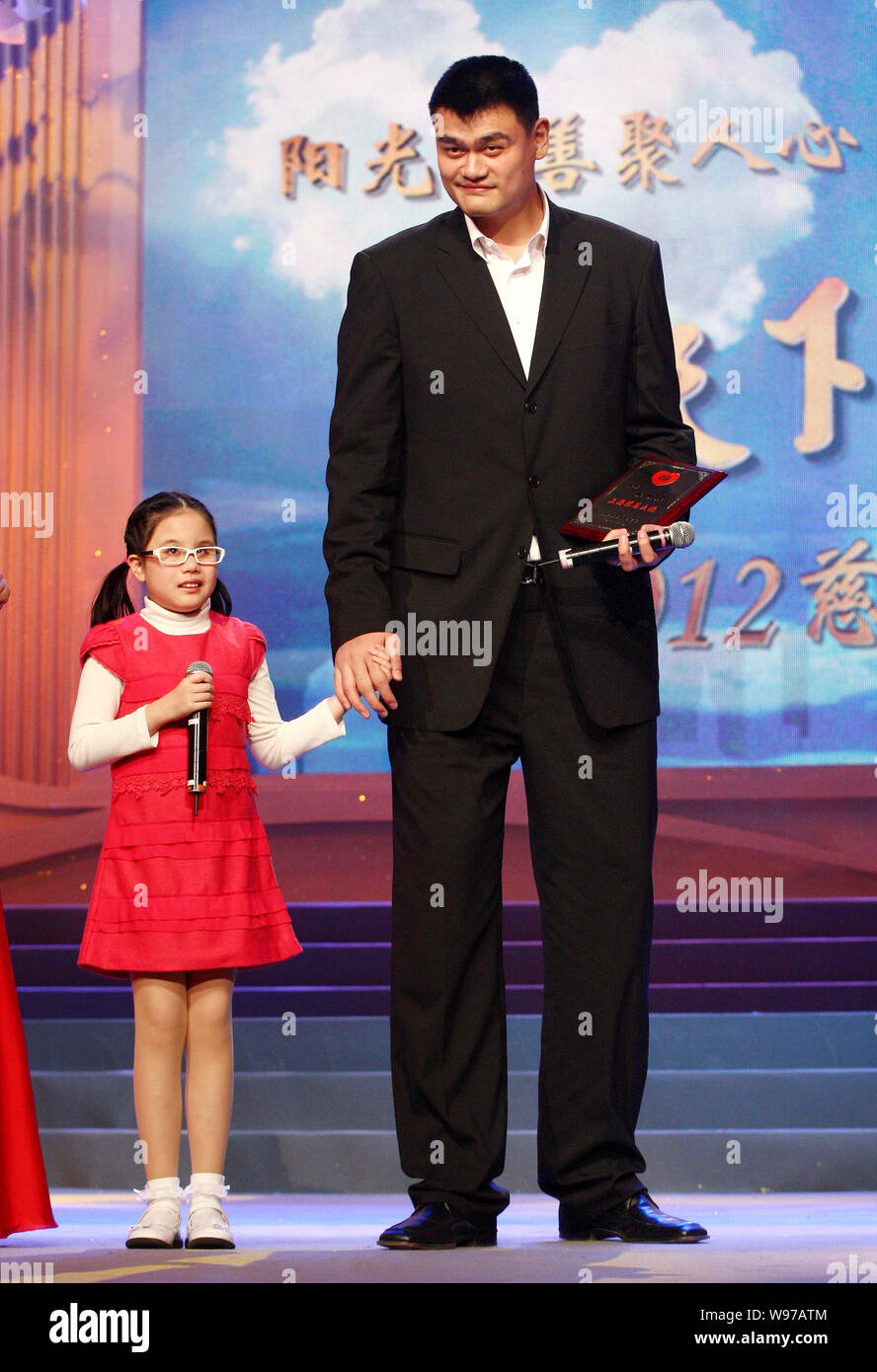Retired Chinese basketball superstar Yao Ming stands next to a young  student from Shanghai School for the Blind at a charity TV gala in  Shanghai, Chin Stock Photo - Alamy