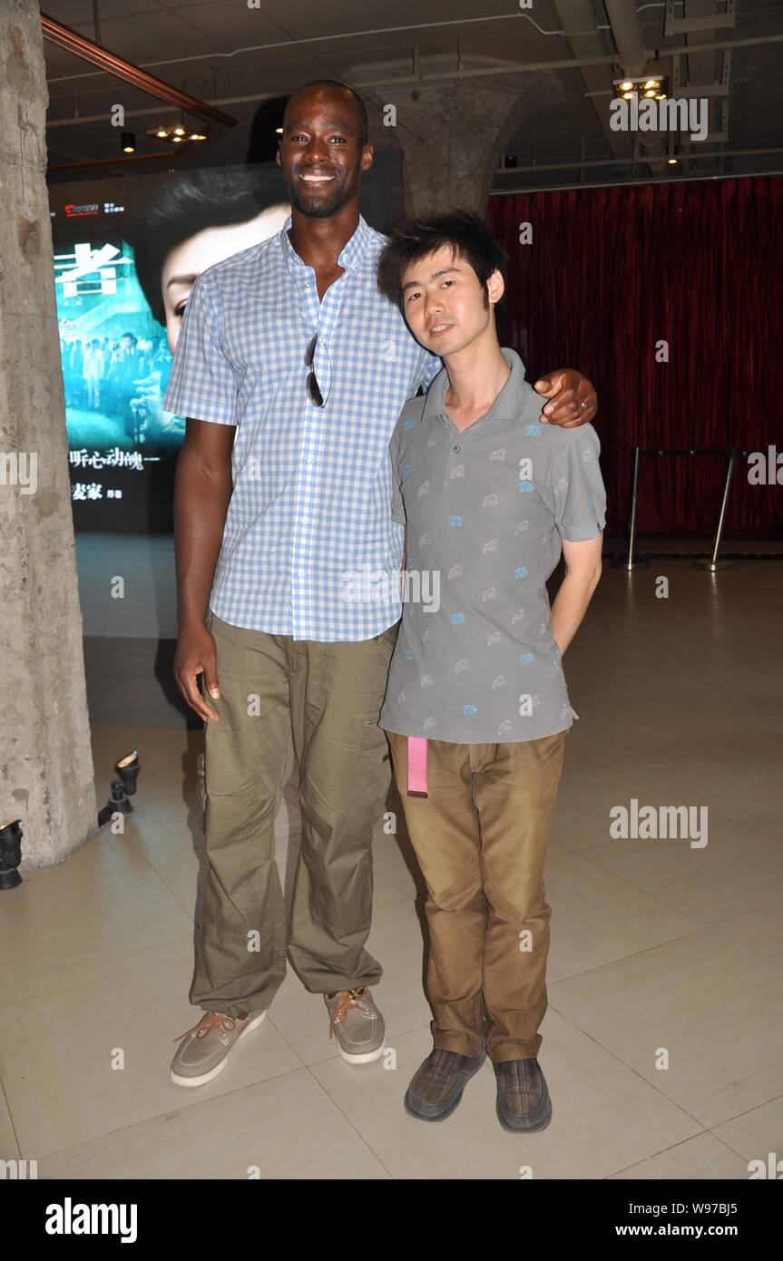 NBA star Emeka Okafor of the New Orleans Hornets poses with a fan after a press conference for the movie, The Silent War, in Shanghai, China, 31 July Stock Photo