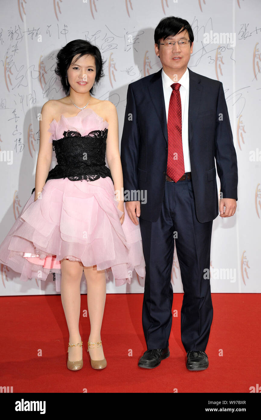 Chinese chess prodigy Hou Yifan, left, poses with her coach Ye Jiangchuan on the red carpet before the 2011 CCTV Sports Personality Award Ceremony in Stock Photo