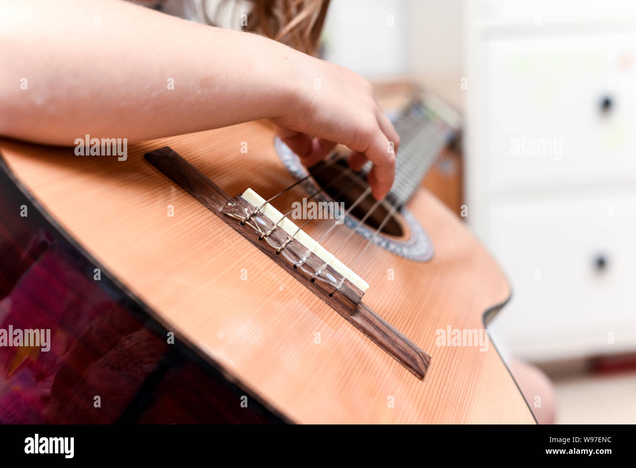 Girl learns to play guitar during a music lesson on the instrument Stock Photo