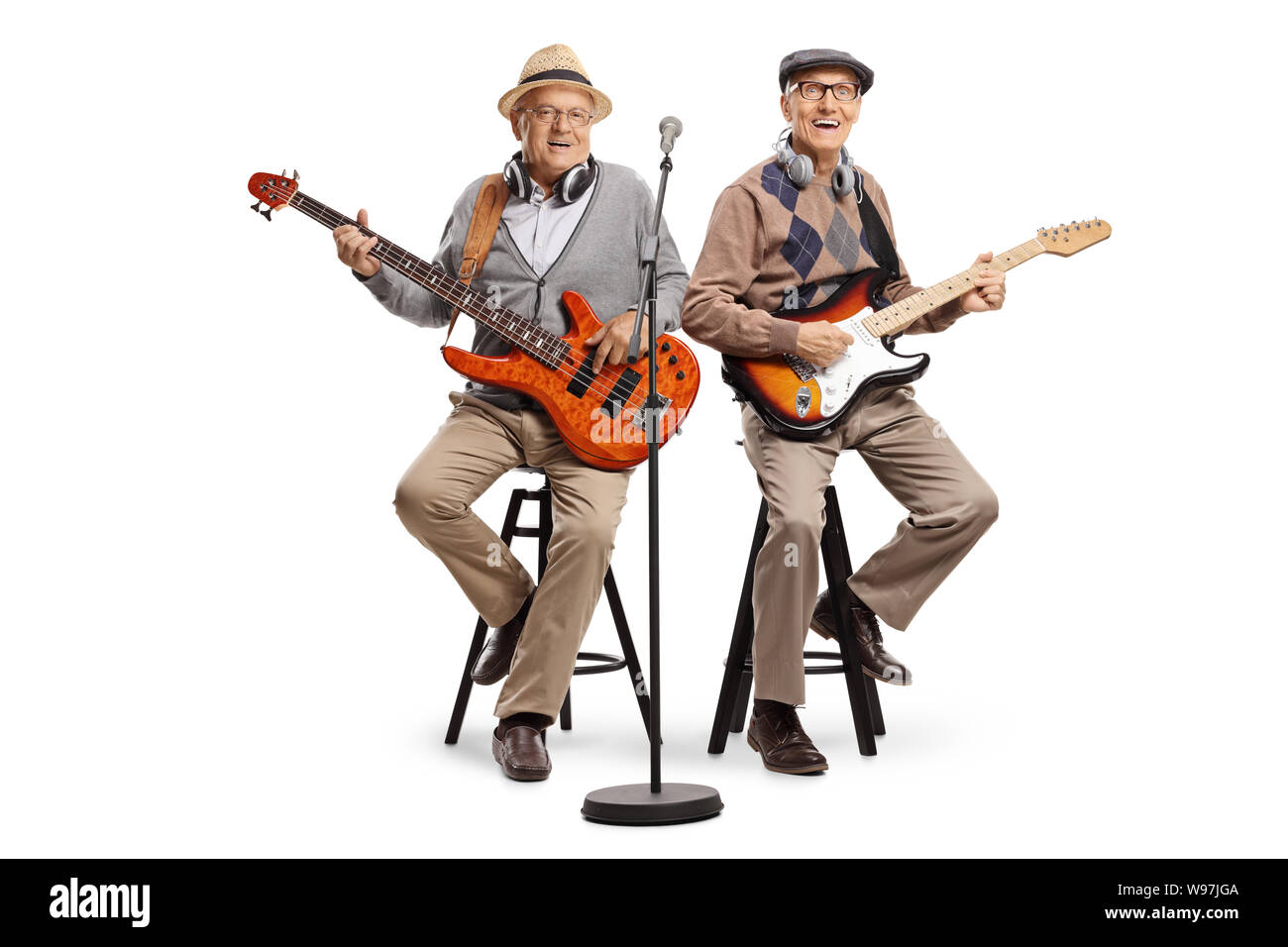 Full length shot of two senior men sitting and playing electric guitars isolated on white background Stock Photo
