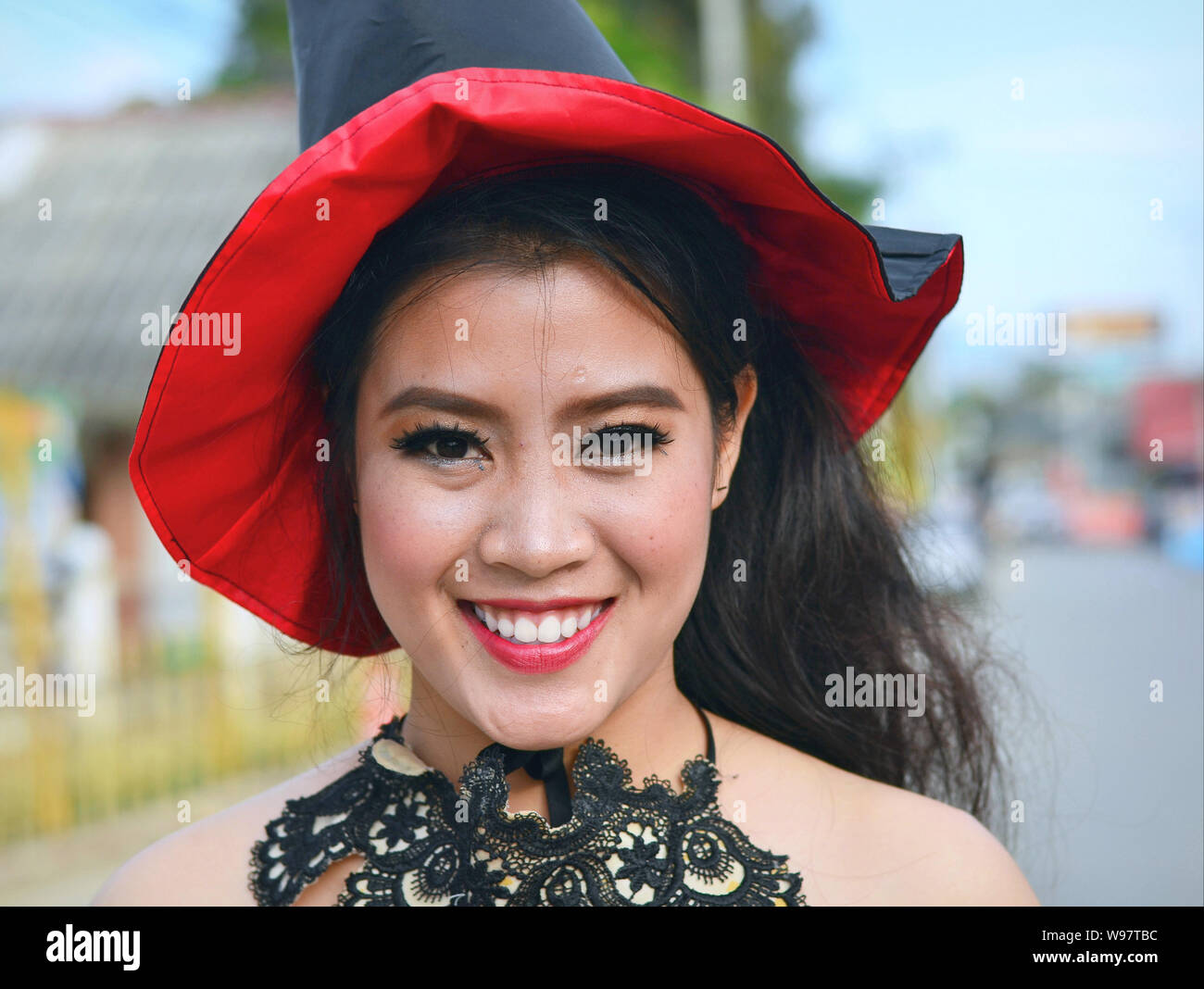 Costumed pretty Thai girl takes part in the village's historical Lanna street parade and smiles for the camera. Stock Photo