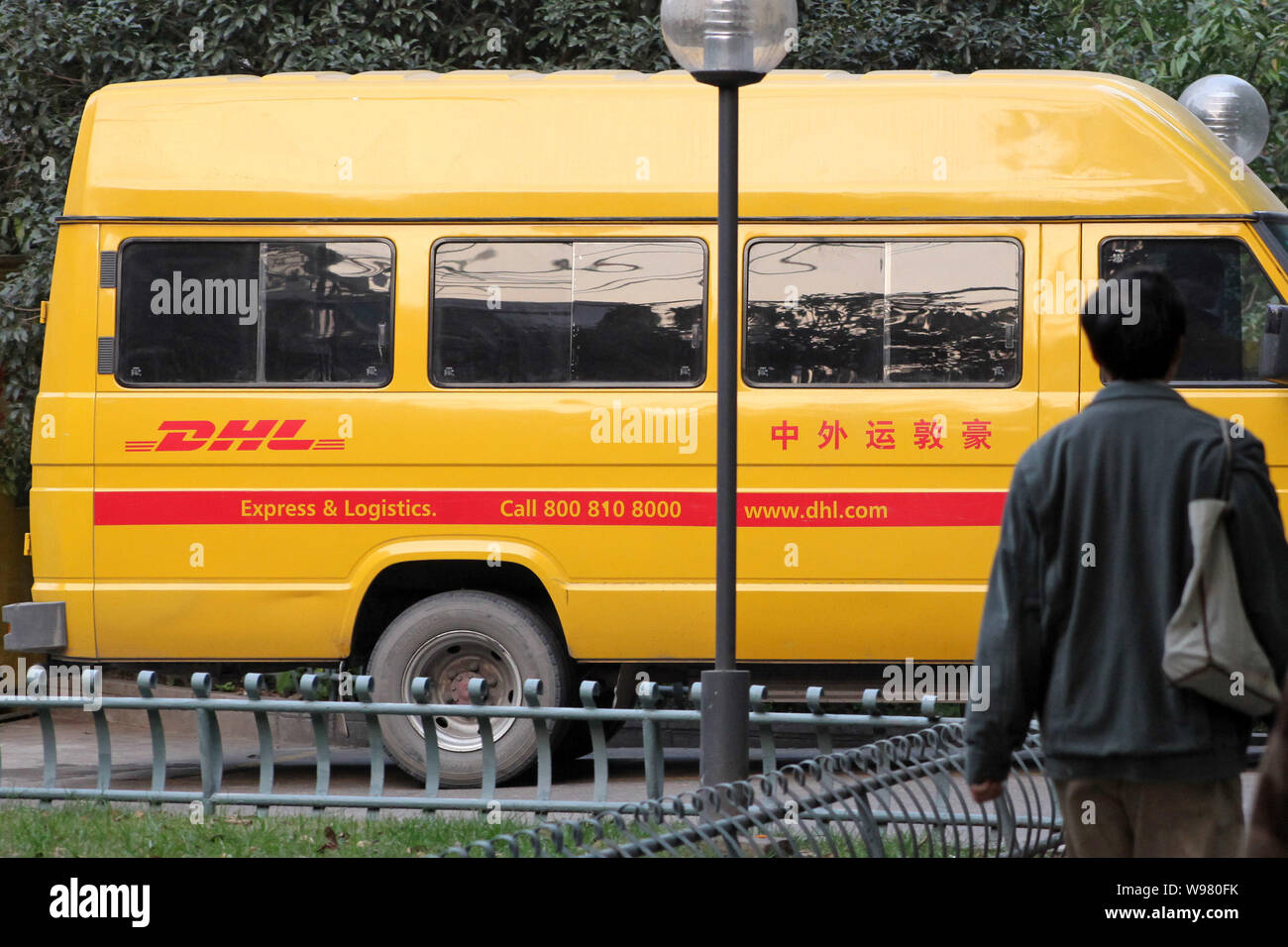 File--A pedestrian walks past a DHL van in Shanghai, China