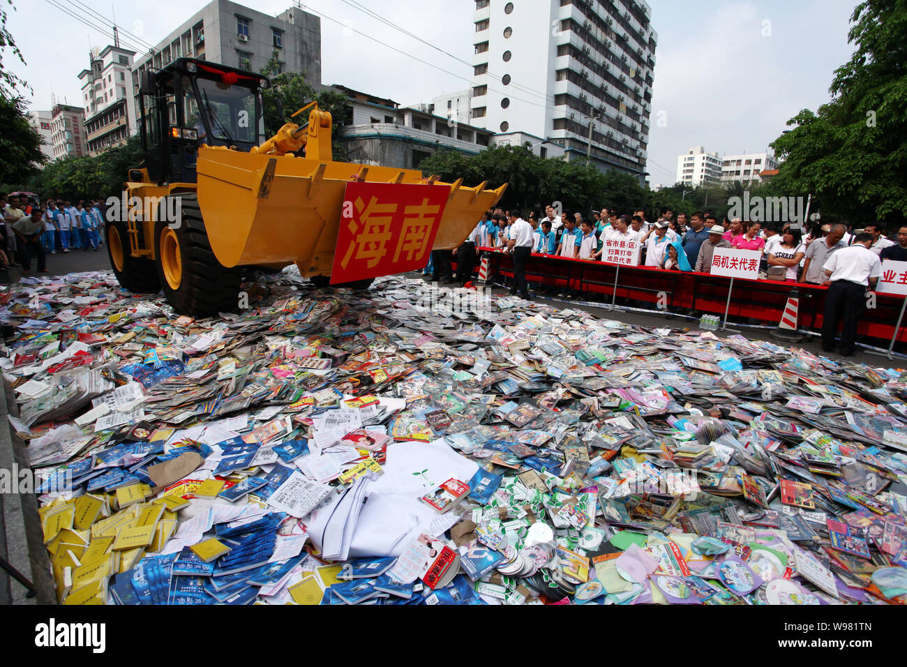 --FILE--A bulldozer destroys pirated DVDS and books in Haikou city, south Chinas Hainan province, 22 April 2011.  Chinese piracy and counterfeiting of Stock Photo