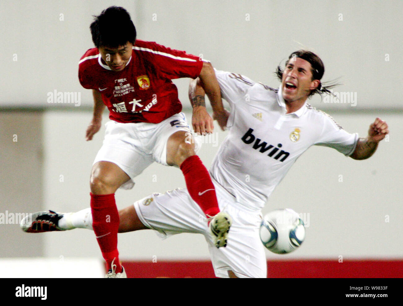 Sergio Ramos of Real Madrid, right, challenges Yang Yihu of Guangzhou