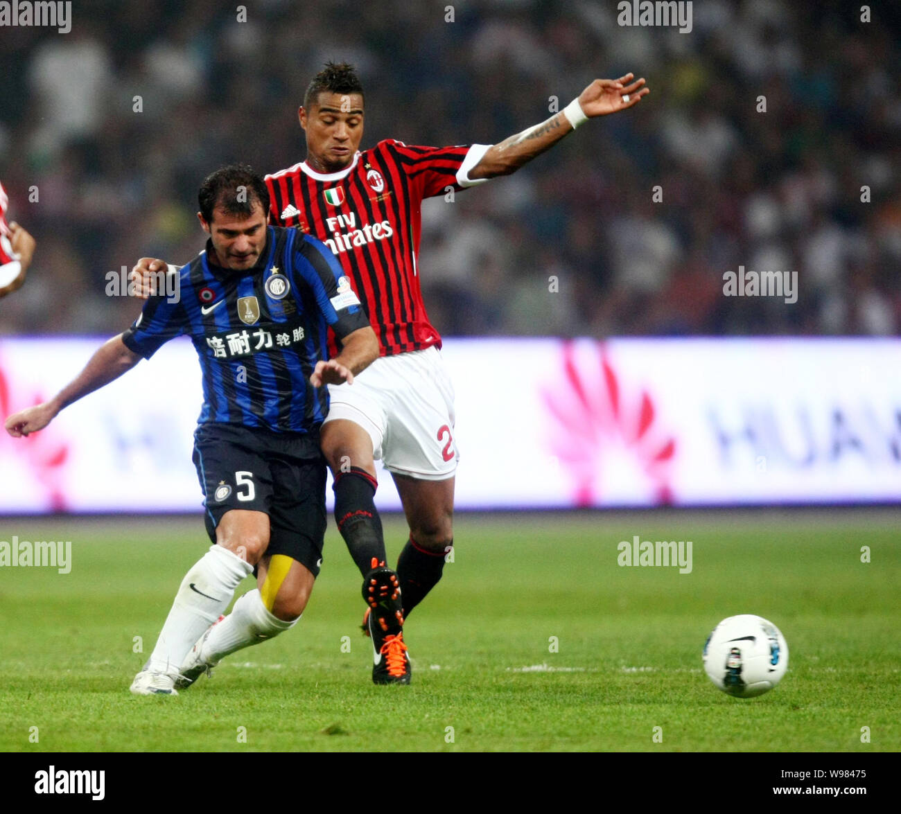 Kevin-Prince Boateng of AC Milan, right, challenges Dejan Stankovic of Inter Milan during the Italian Super Cup 2011 match at the National Stadium, kn Stock Photo