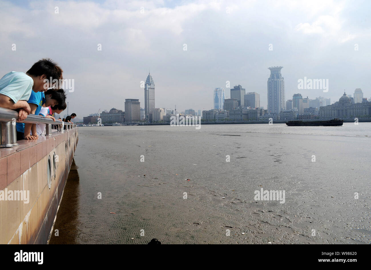 Visitors look at the low water level of the muddy Huangpu Riverin Shanghai, China, 26 May 2011.   Salt tide is likely to affect Shanghai again in June Stock Photo