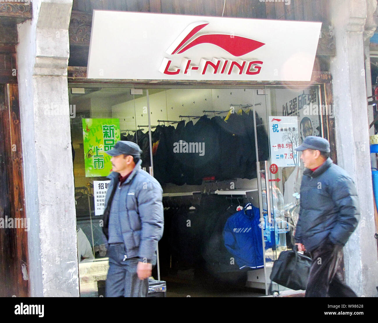 Local residents walk past a Li-Ning sportswear boutique in Shanghai, China, December 29, 2010.   Chinese athletic shoe maker Li-Ning knew it could not Stock Photo