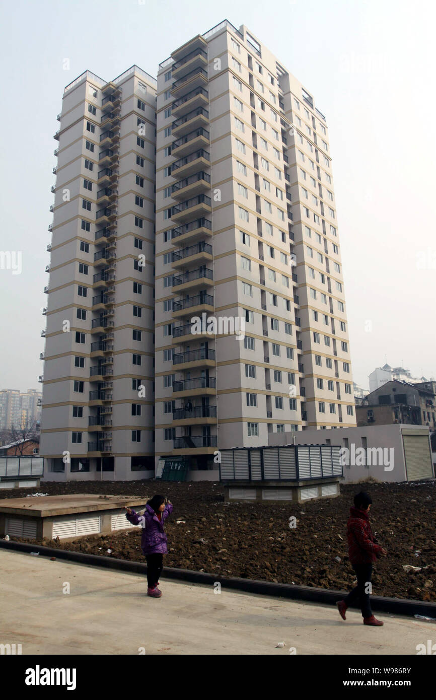 --File-- Chinese kids walk past some newly built residential apartment buildings in Wuhan city, central Chinas Hubei Province, January 23, 2011.   Chi Stock Photo