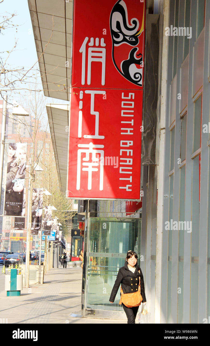 --FILE--A local resident walks past the logo of South Beauty restaurant in Shanghai, China, 12 April 2011.  In only 11 years, cook-turned-entrepreneur Stock Photo