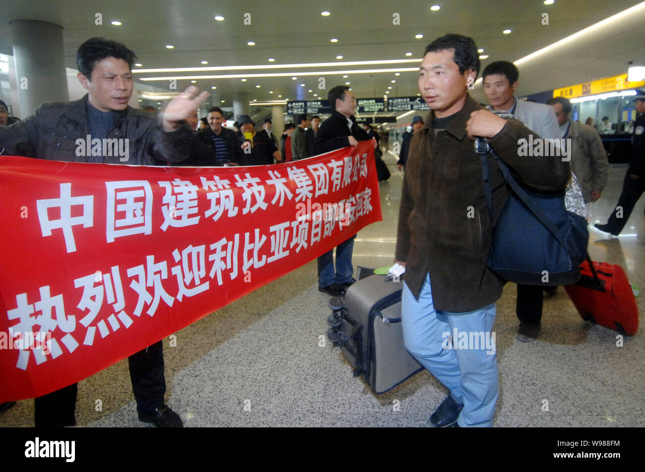 Workers from China Building Technique Group Co., Ltd., evacuated from the violence-torn Libya, arrive at the Pudong International Airport in Shanghai, Stock Photo