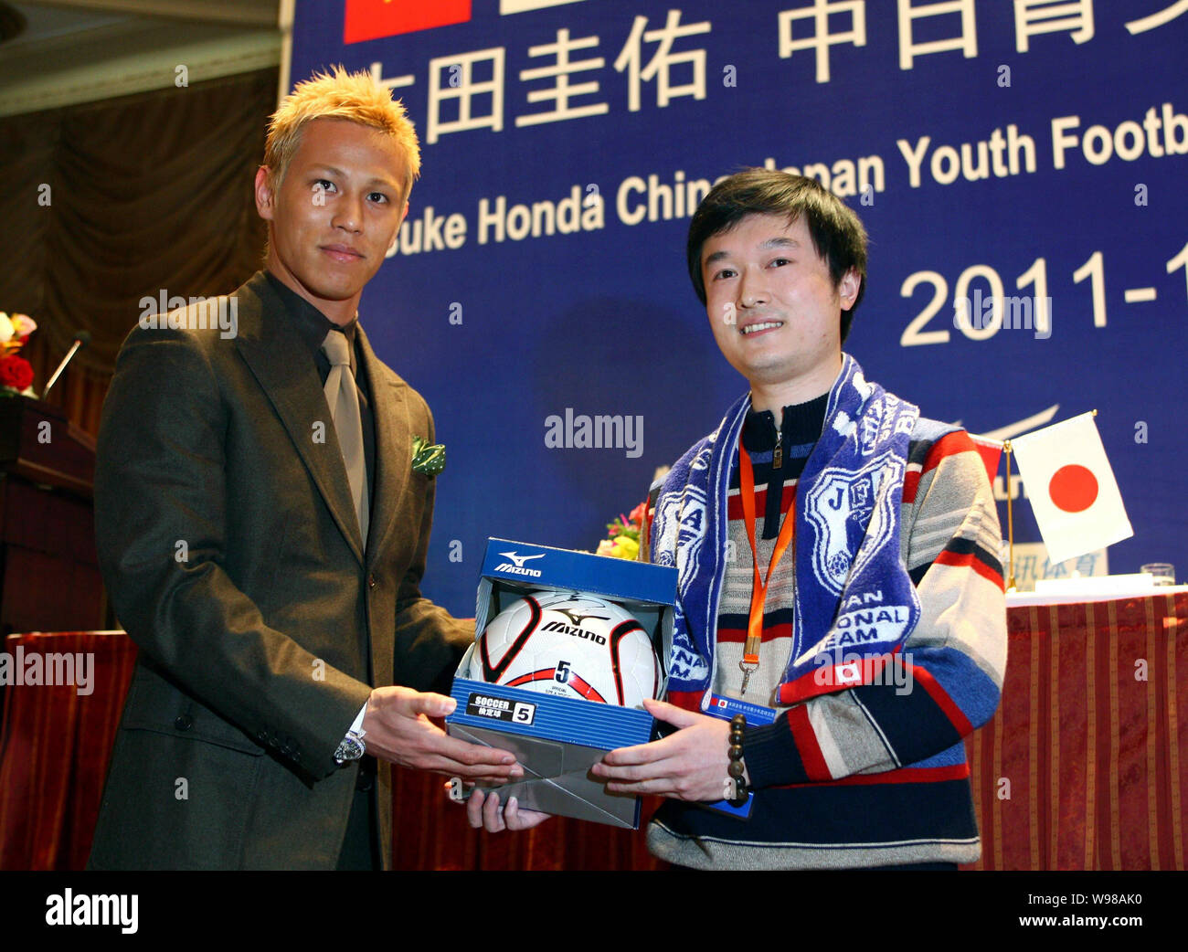 Japanese football player Keisuke Honda, left, presents a gift to a soccer fan at a press conference for the China-Japan Youth Football Exchange Progra Stock Photo