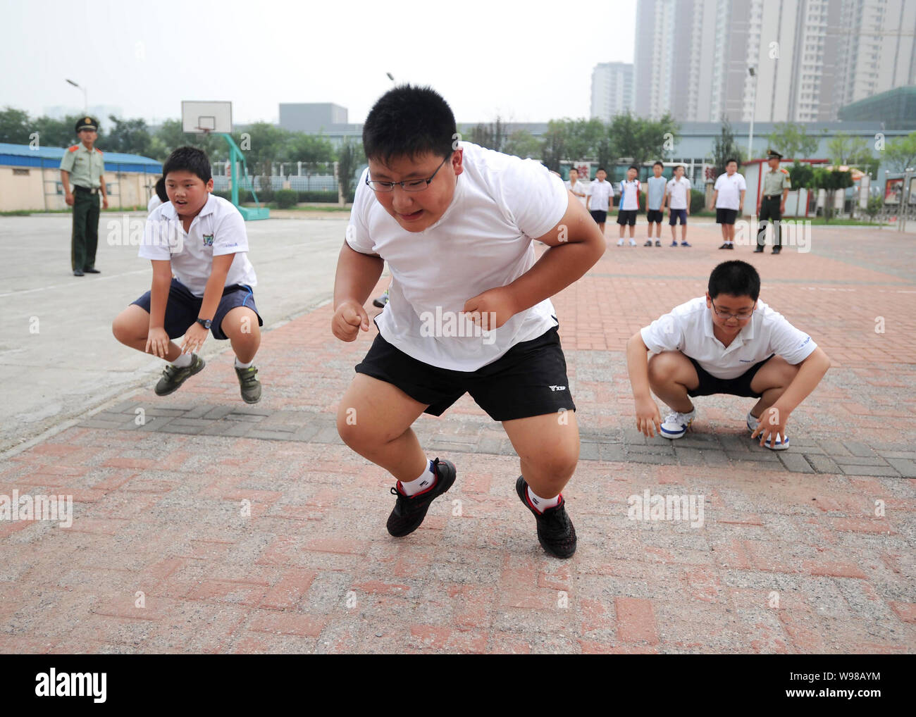 Obese boys leap during an exercise to lose weight at a military training camp in Tianjin, China, 13 August 2011.   Chinas spoilt generation of single Stock Photo