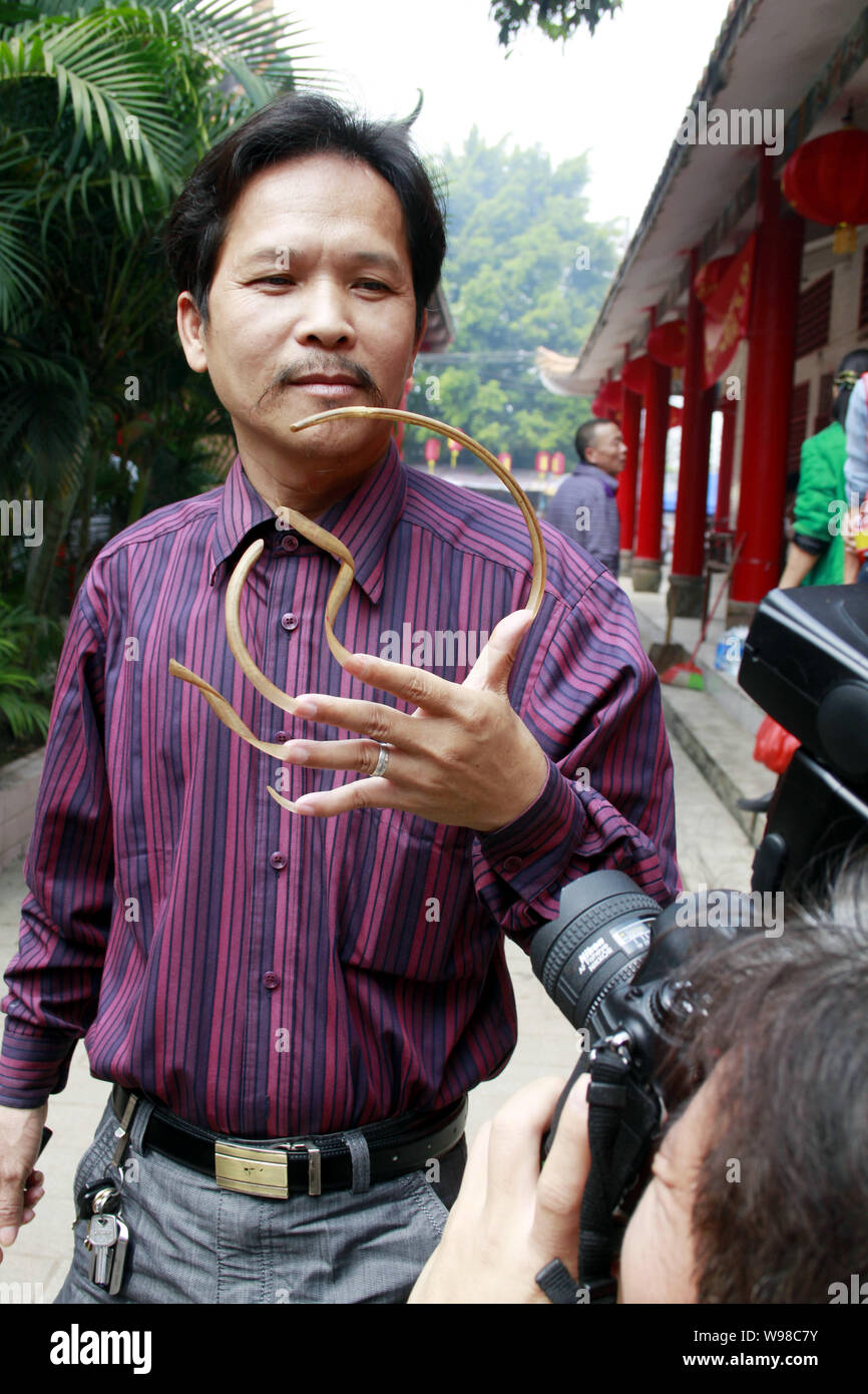 A Chinese man surnamed Feng shows off his long fingernails in Haikou city, south Chinas Hainan Province, March 13, 2011. Stock Photo