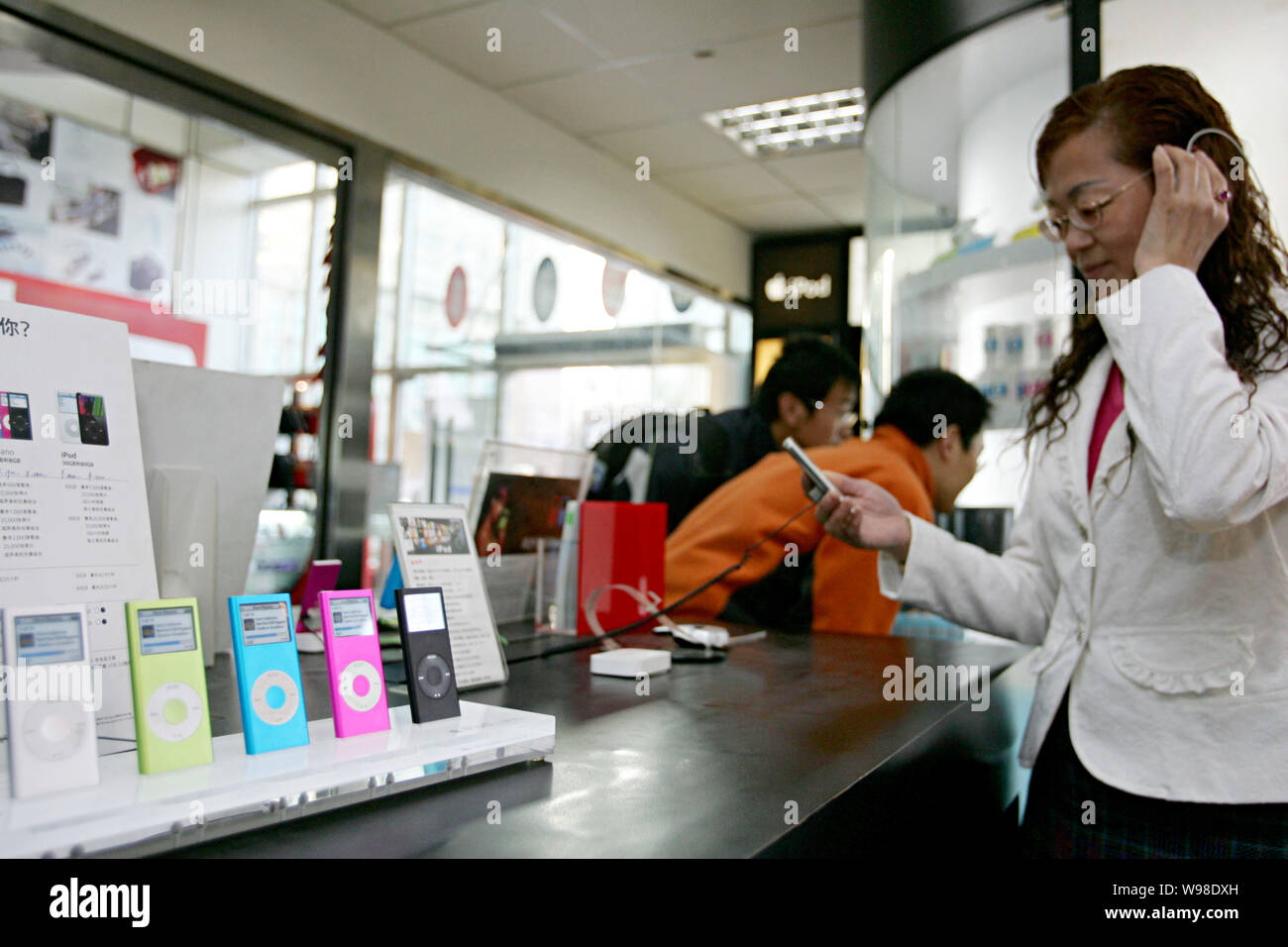 --FILE--Chinese customers try out Apple iPod nano music players at a digital products store in Shanghai, China, 16 April 2007.   Apple has unveiled a Stock Photo