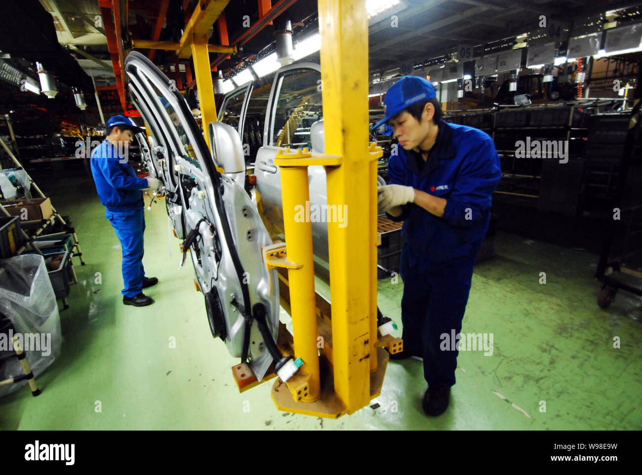 --FILE--Chinese factory workers assemble Suzuki Liana cars on the ...