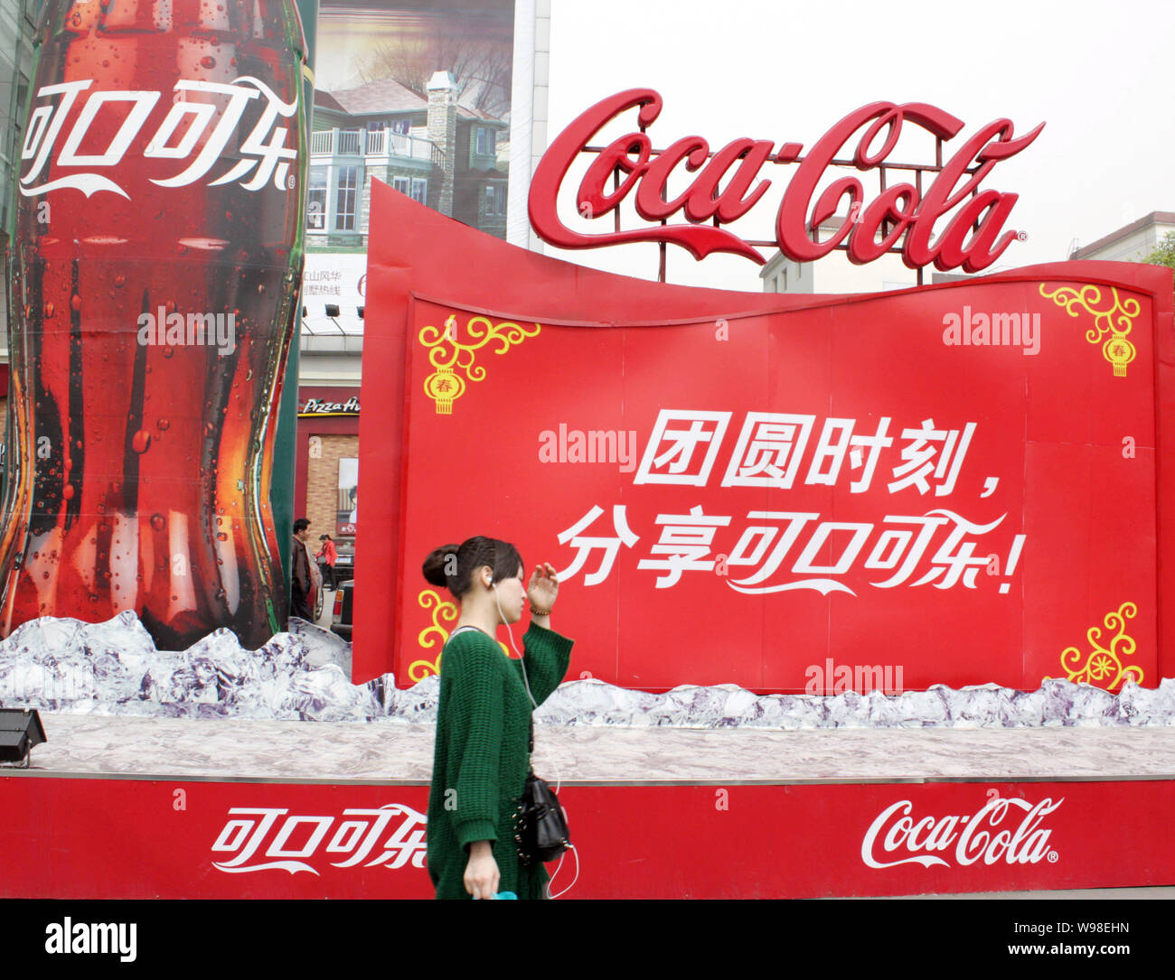 --FILE--A local resident walks past an advertising of Coca Cola in ...