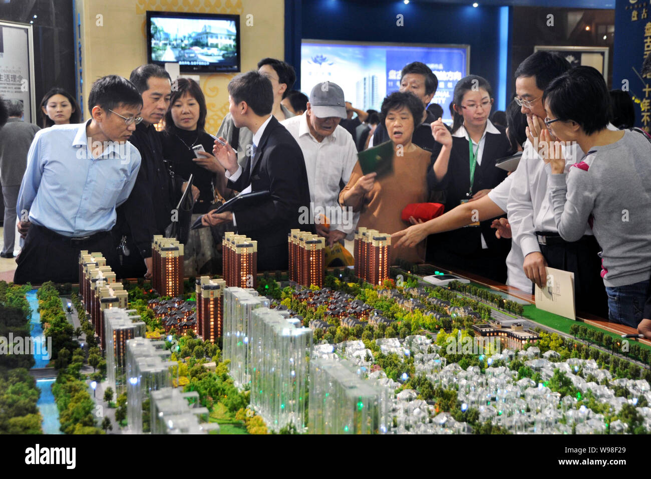 --File-- Chinese home buyers look at models of a residential project during a property fair in Shanghai, China, October 3, 2010.   New property guidel Stock Photo