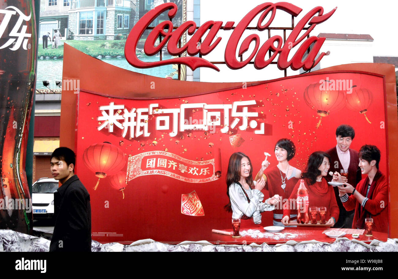 --FILE--A Chinese man walks past an advertisement for coca-Cola in ...