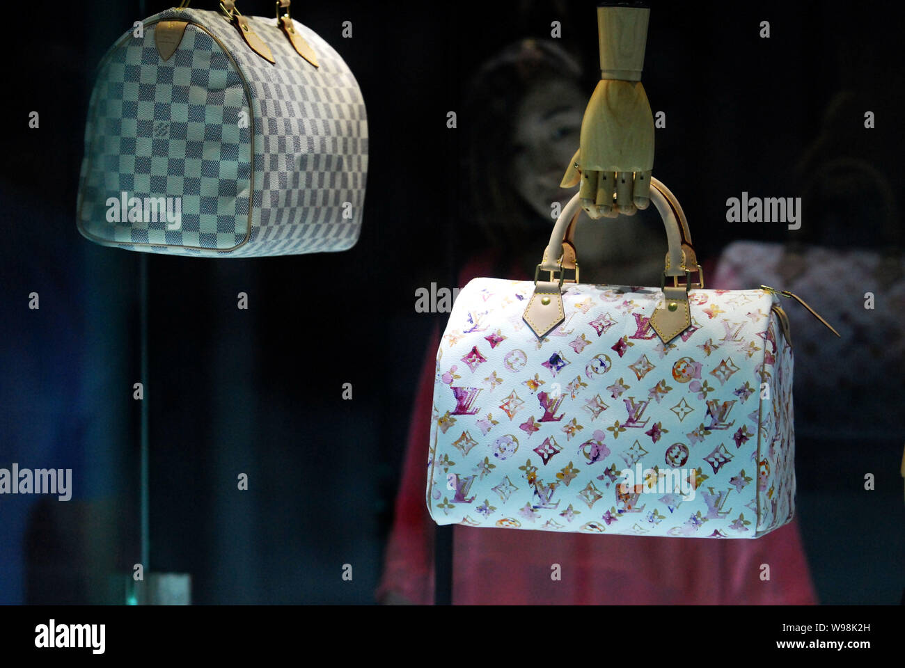FILE--A visitor looks at Louis Vuitton (LV) handbags during the