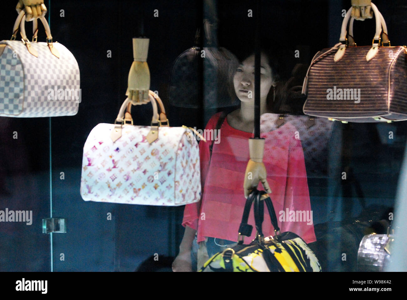 A visitor looks at handbags on display during the Louis Vuitton Voyages  exhibition at the National Museum of China in Beijing, China, 31 May 2011.  A Stock Photo - Alamy