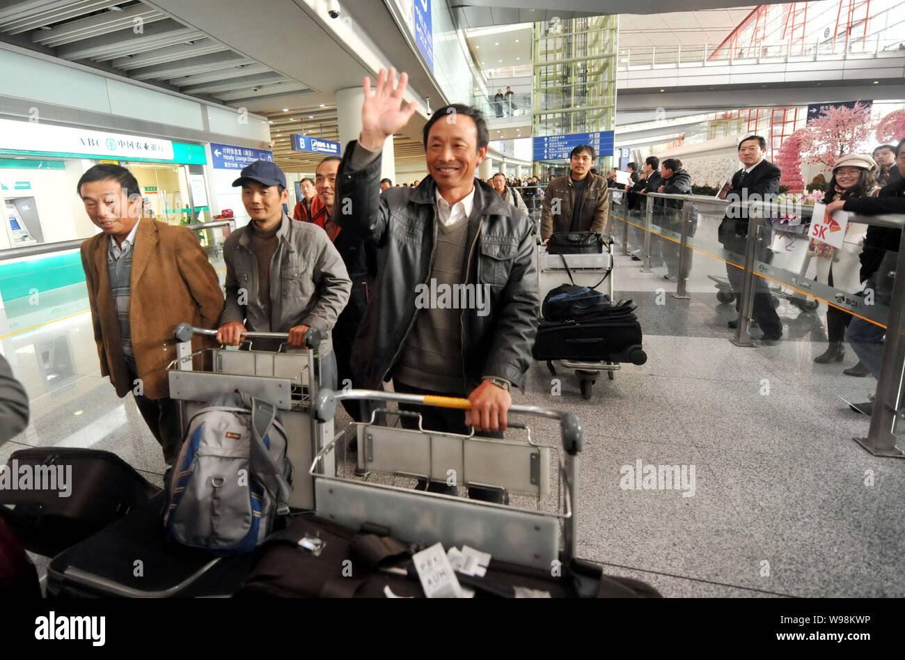 Workers from China Building Technique Group Co., Ltd., evacuated from the violence-torn Libya, arrive at the Beijing Capital International Airport in Stock Photo