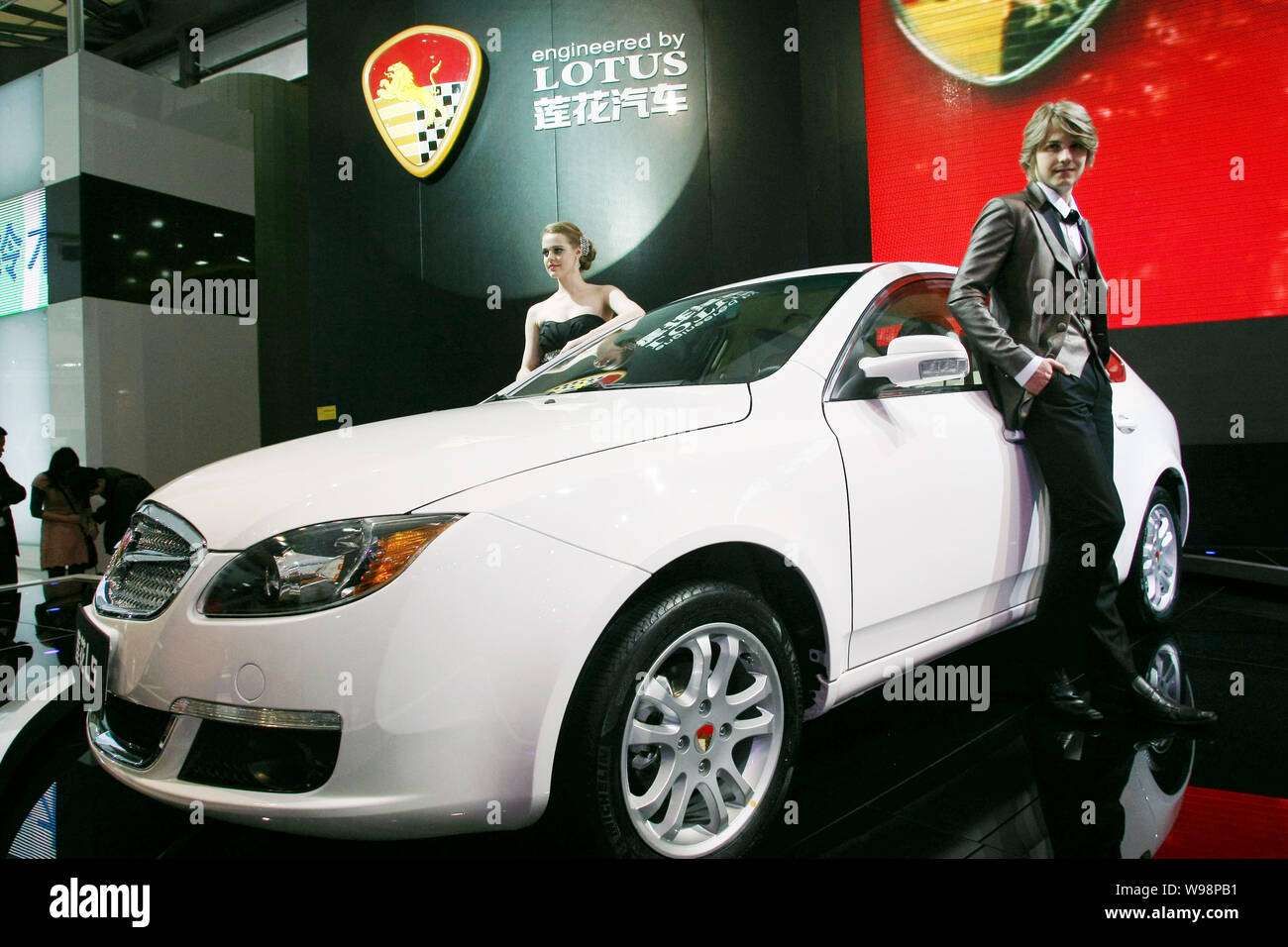 FILE--Two models pose next to the Lotus L5 at the 14th Shanghai  International Automobile Industry Exhibition, known as Auto Shanghai 2011,  in Shangh Stock Photo - Alamy