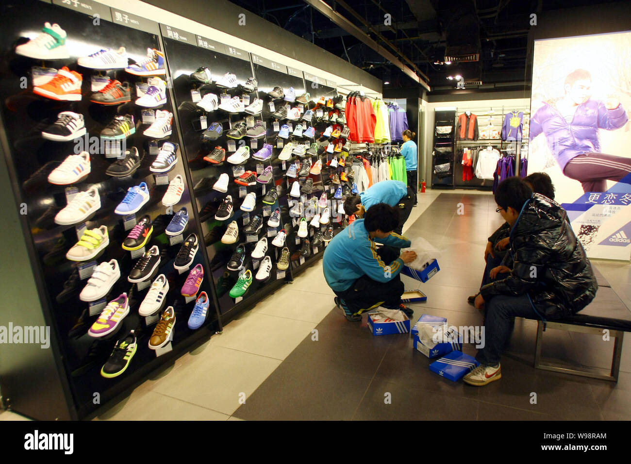 Chinese customers shop for Adidas sports shoes in an Adidas sportswear  store in Shanghai, China, 23 February 2011. Adidas AG posted record sales  and Stock Photo - Alamy