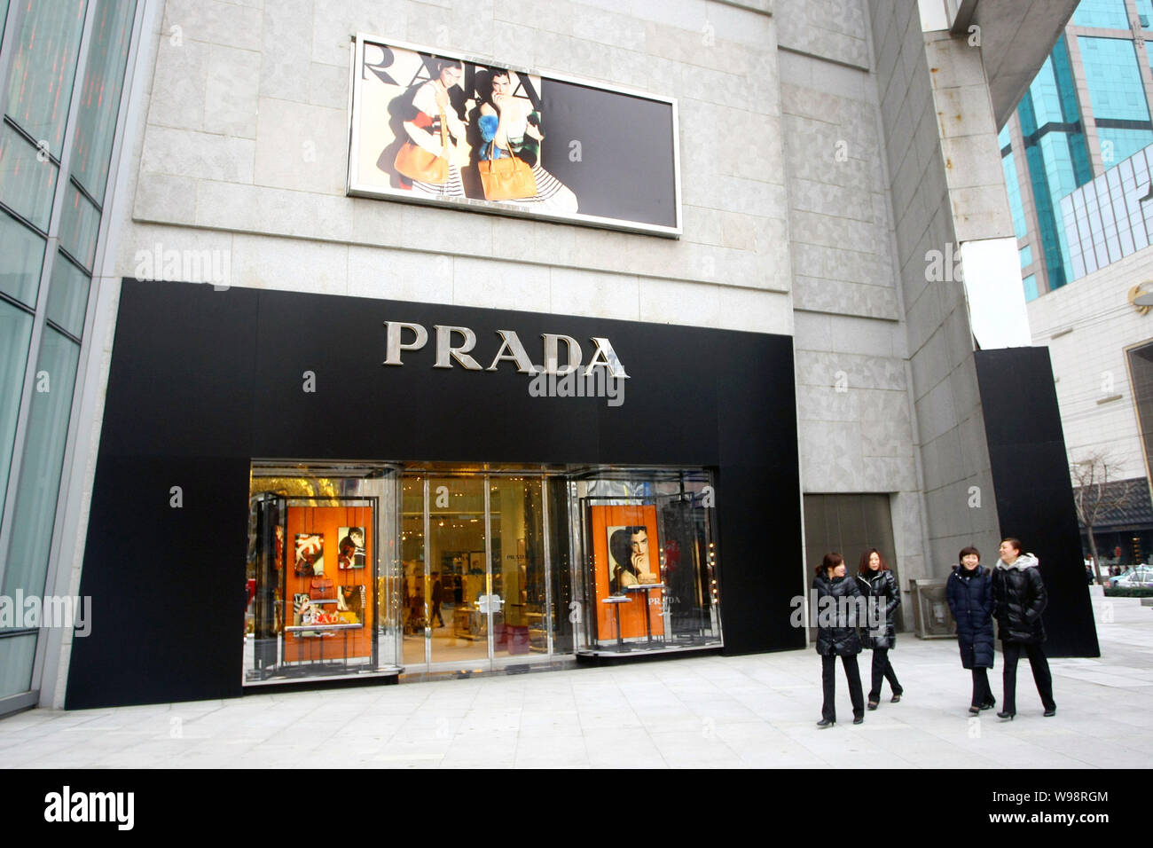 Local residents walk past a Prada boutique in Shanghai, China, January 21,  2011. Prada SpA, the fashion house known for its Miu Miu bags and Churchs  Stock Photo - Alamy