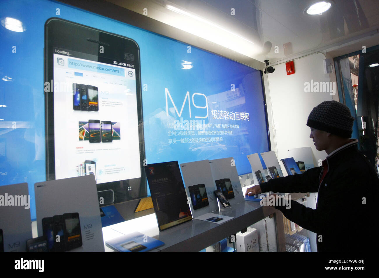 A Chinese customer tries out the Meizu M9 smartphone at a Meizu mobile phone store in Shanghai, China, 5 January 2011.   The China Telecom Industry As Stock Photo