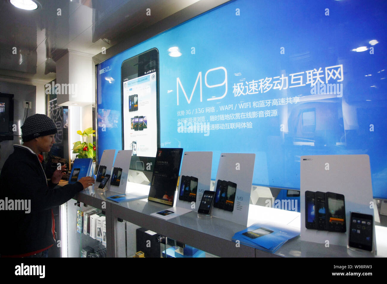 A Chinese customer tries out the Meizu M9 smartphone at a Meizu mobile phone store in Shanghai, China, 5 January 2011.   The China Telecom Industry As Stock Photo