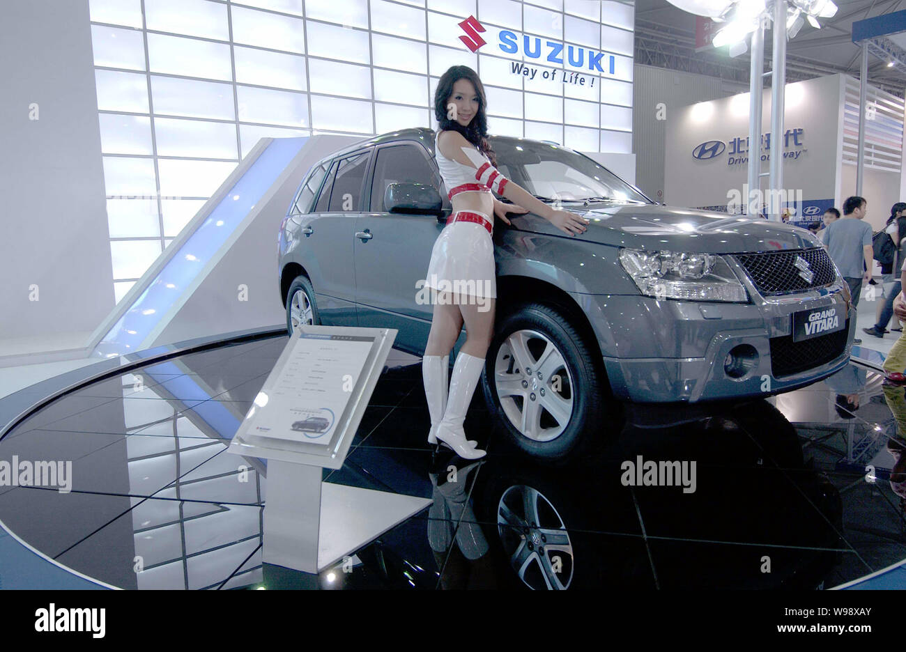 --FILE--A model poses next to a Suzuki Grand Vitara during an auto show in Chengdu city, southwest Chinas Sichuan province, 23 September 2007.   Suzuk Stock Photo