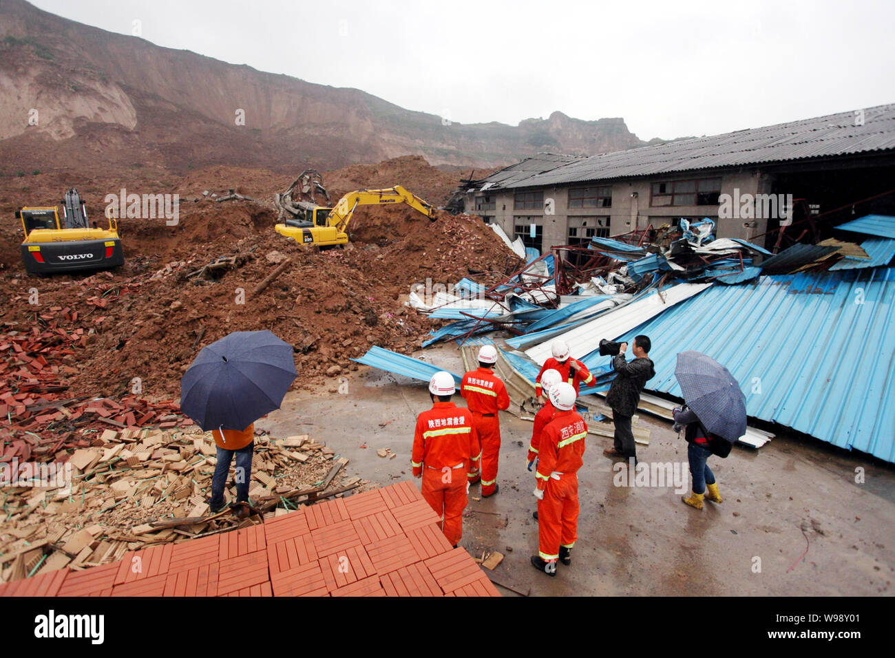 Excavators clean up the debris of a workshop devastated by a landslide ...