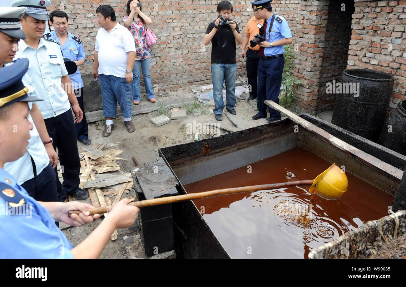 FILEChinese law enforcement officers check waste oil at an illegal
