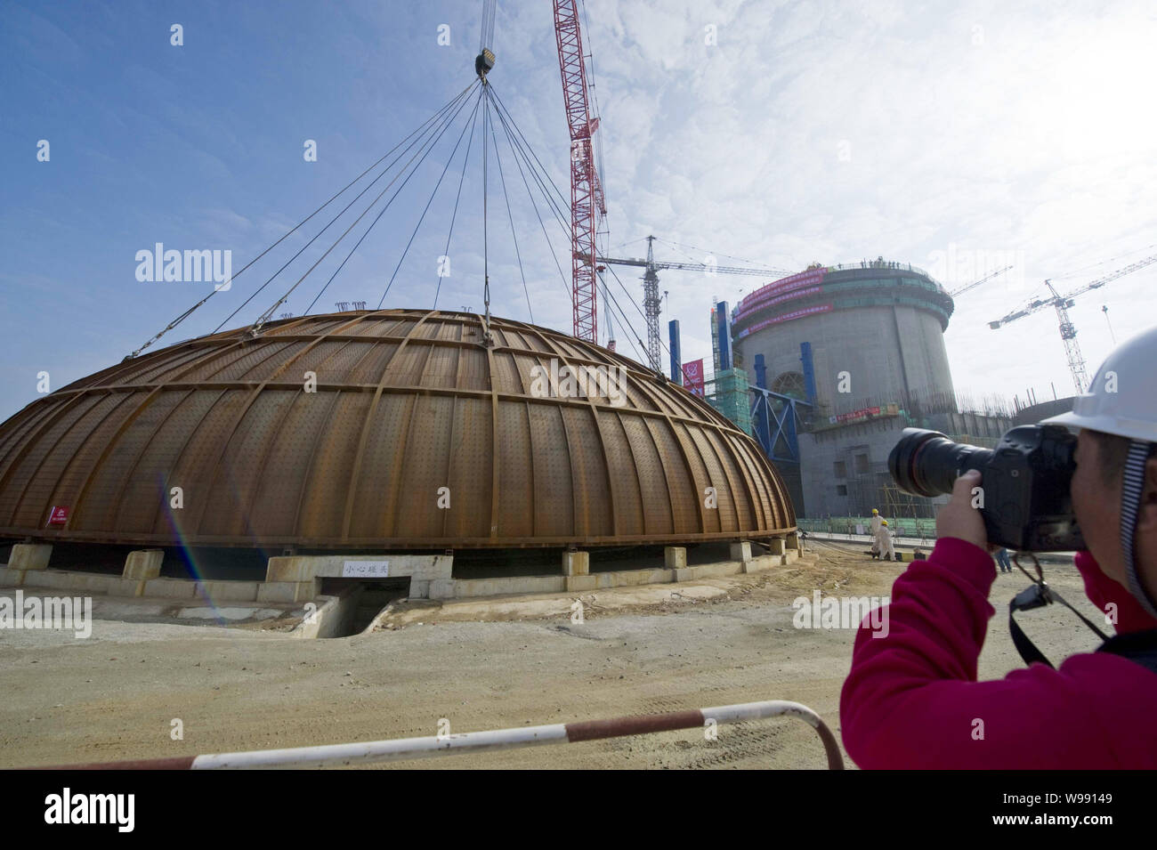 A worker takes photos of the dome of the containment structure for the ...