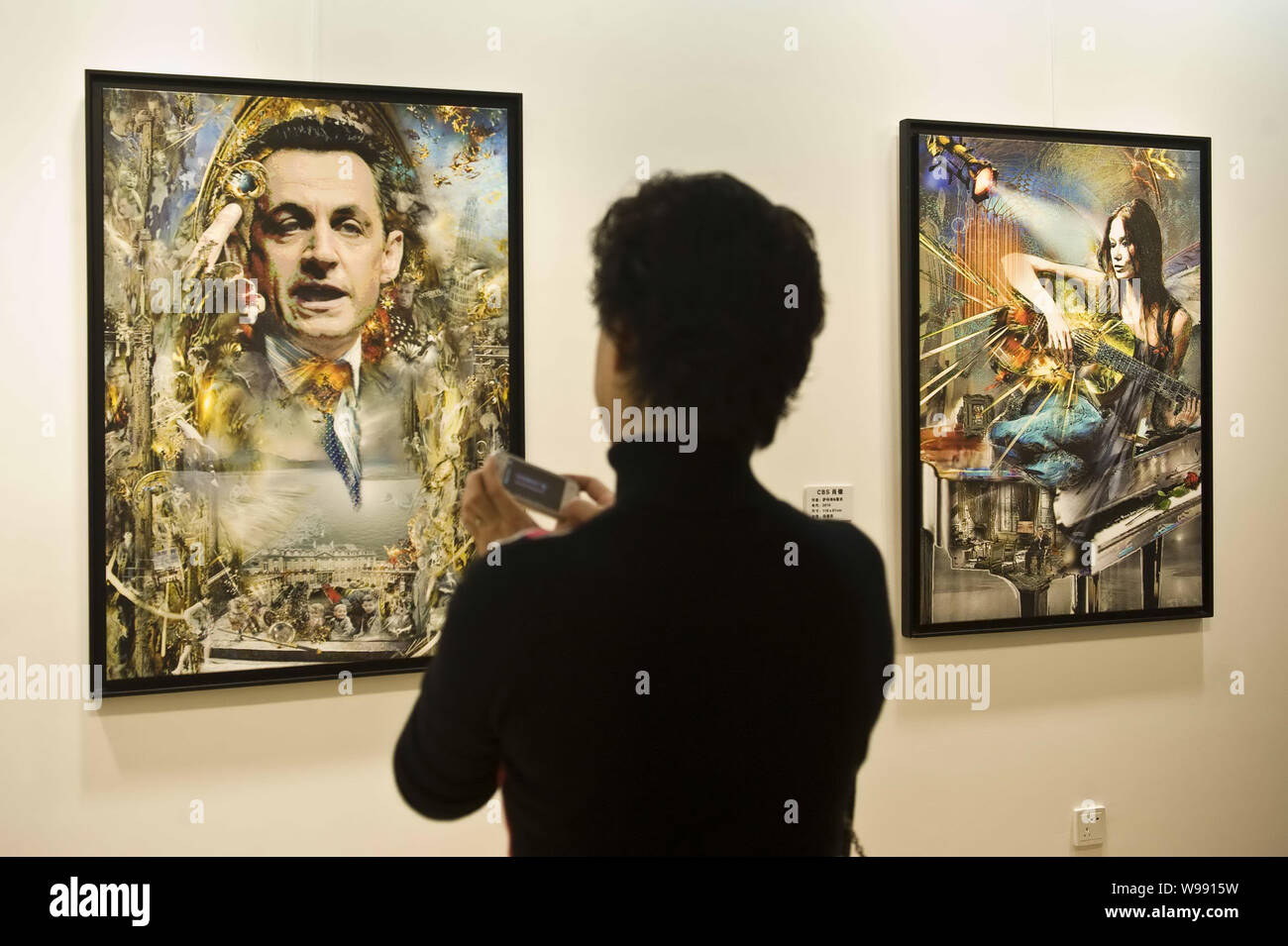 A visitor takes photos of a portrait of Nicolas Sarkozy at an art exhibition featuring the works of Pal Sarkozy, father of French President Nicolas Sa Stock Photo
