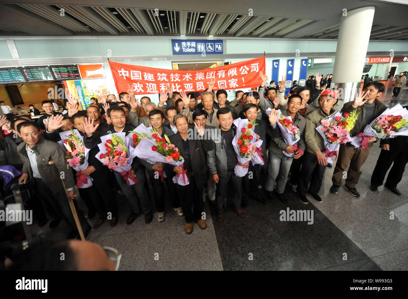 Workers from China Building Technique Group Co., Ltd., evacuated from the violence-torn Libya, arrive at the Beijing Capital International Airport in Stock Photo