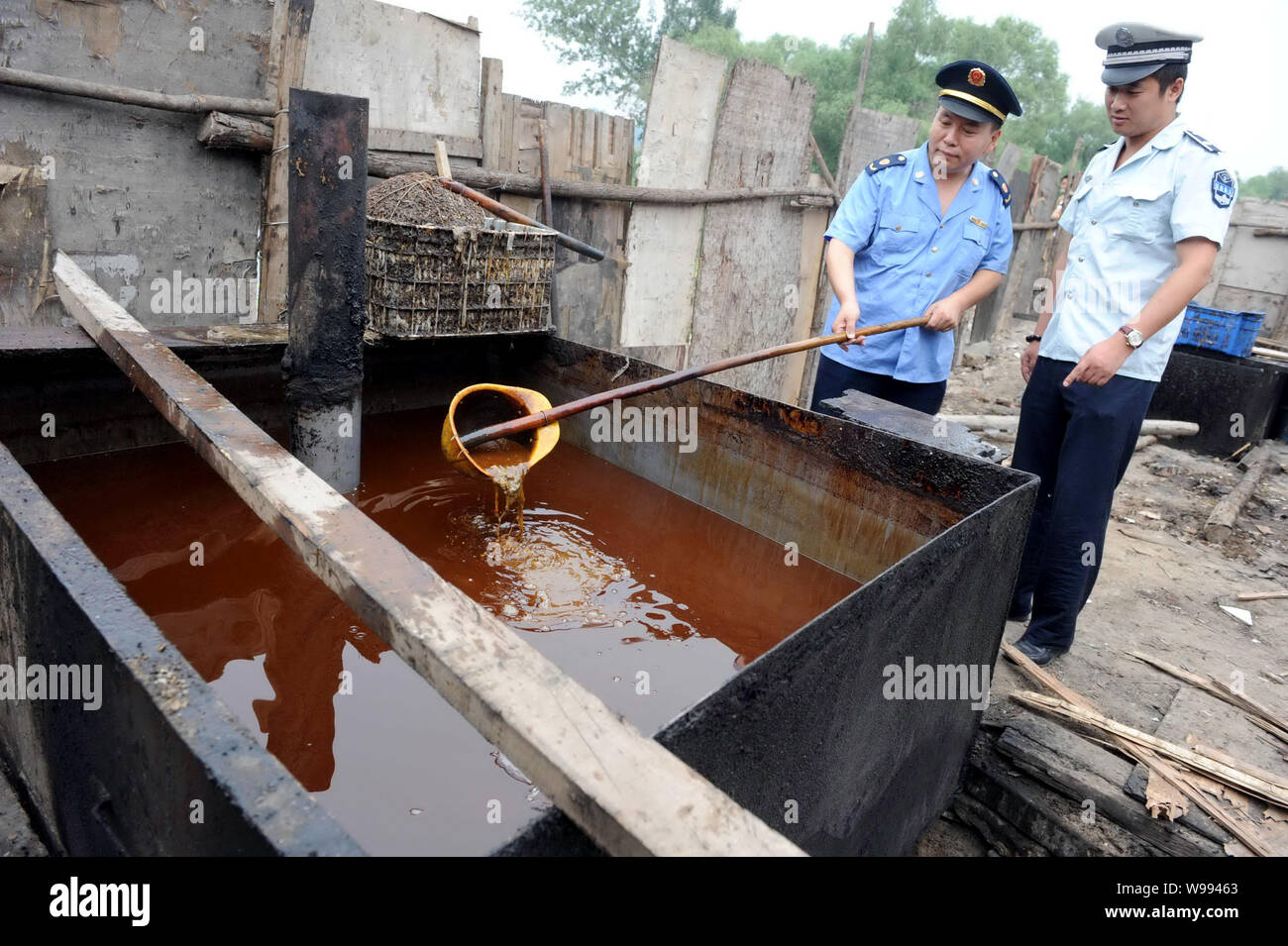 FILEChinese law enforcement officers check waste oil at an illegal