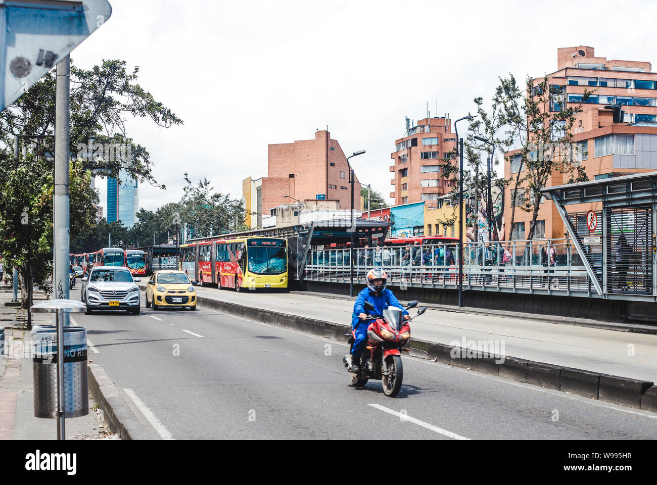 The red Transmilenio public bus system in the bus lane through the center of Bogotá, Colombia's capital city Stock Photo