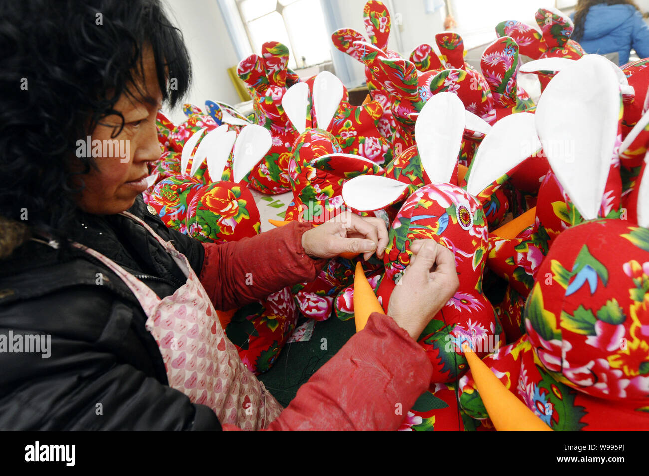A female Chinese worker makes rabbit-shaped craftworks to be exported ...