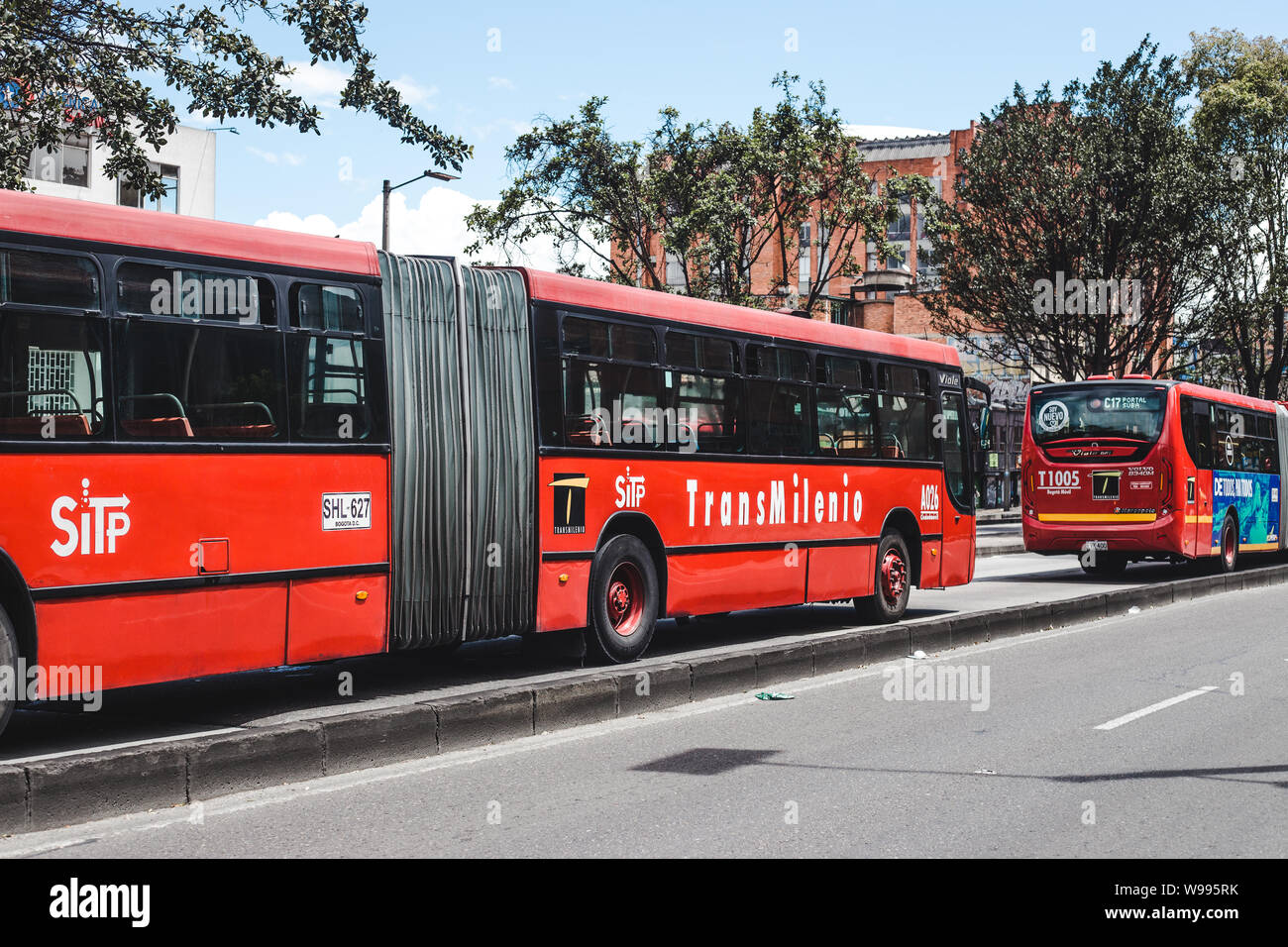 The red Transmilenio public bus system in the bus lane through the center of Bogotá, Colombia's capital city Stock Photo